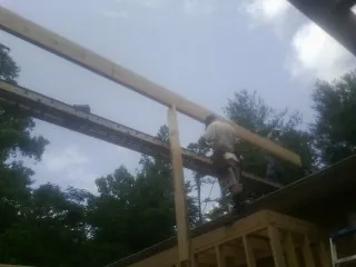 Carpenter setting a ridge beam over a new addition frame — Ice Dam Removal by Roofing Brothers in Berkley