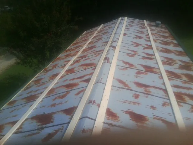 Rusted metal roof panels with new wood purlins before replacement — Storm Damage Roof Repair in Berkley by Roofing Brothers