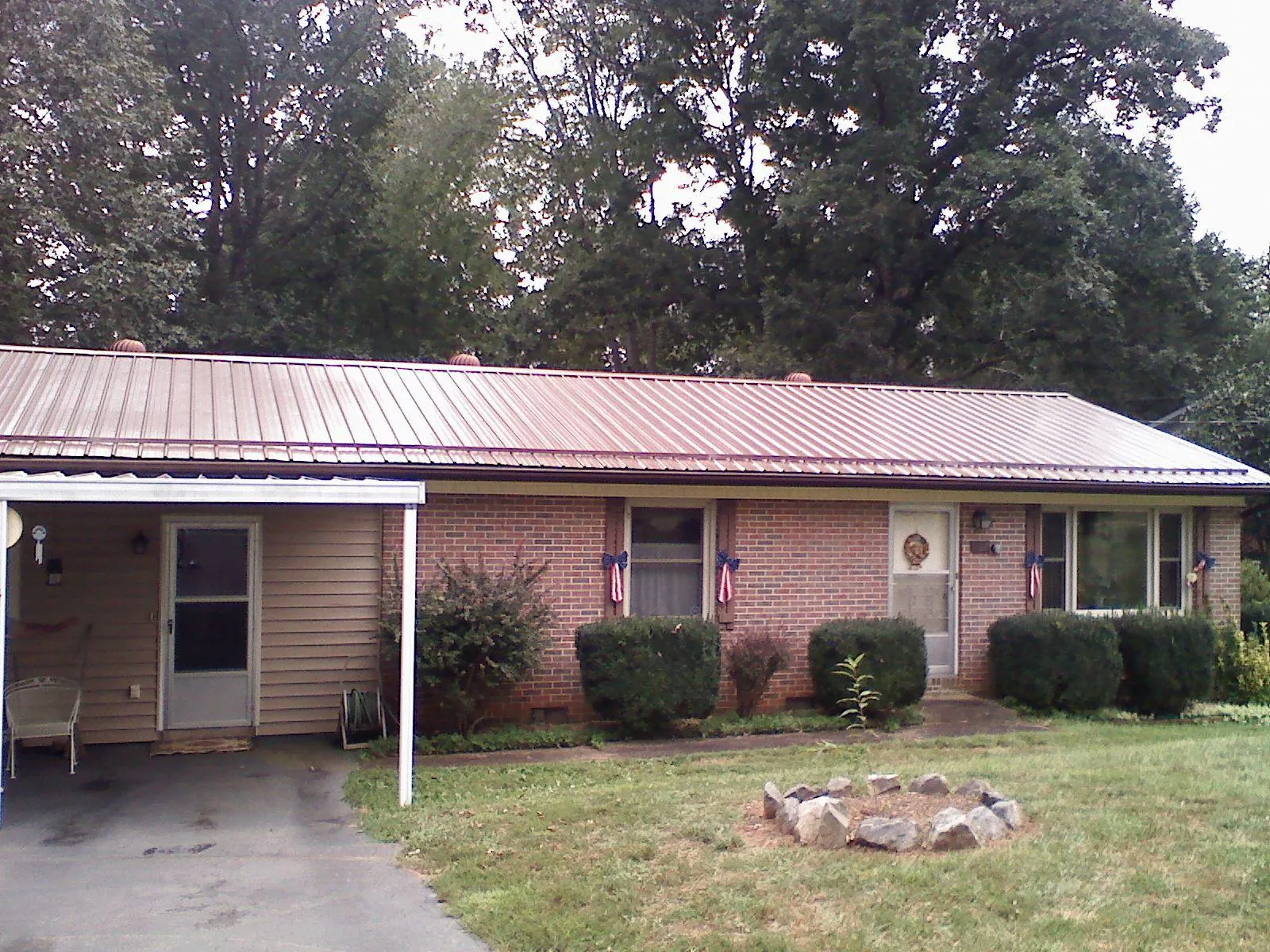 Bronze metal roof and carport on a brick ranch home — Roof Repair work by our crew in Berkley